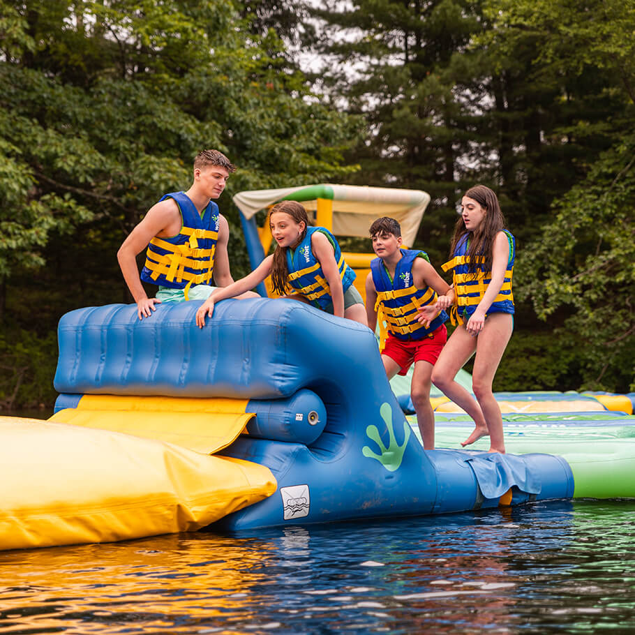 Young kids playing on a blowup water toy