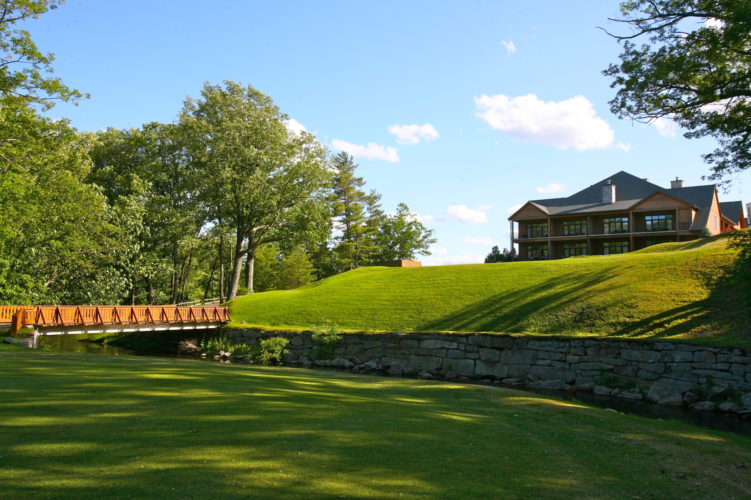skytop lodge golf course with cabin and bridge in the background