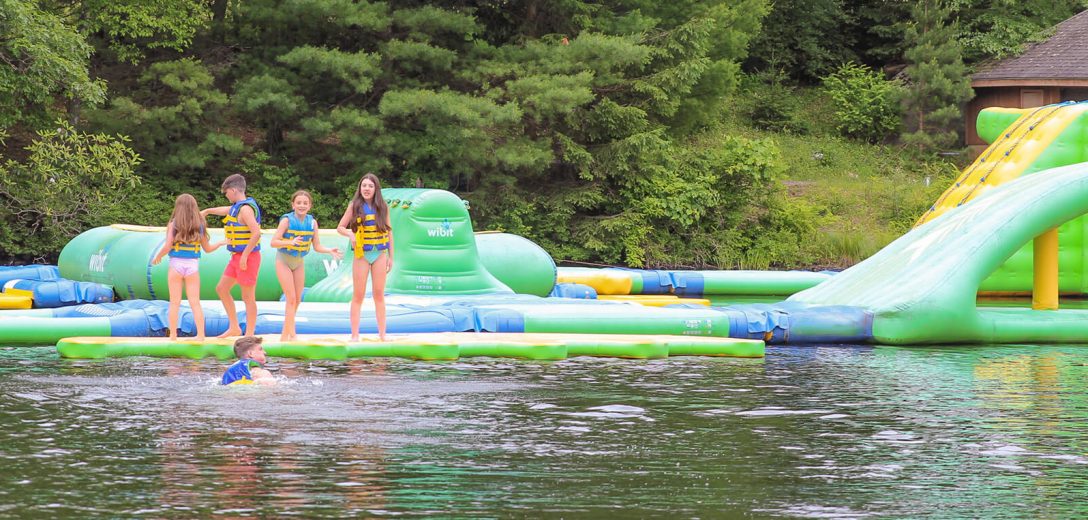 Young kids playing on a blow up water toy