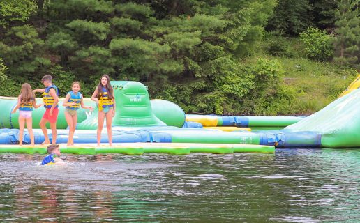 Young kids playing on a blow up water toy