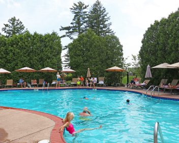 Lots of people in and around an outdoor pool